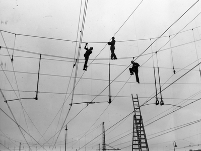 222816 Afbeelding van drie monteurs van de N.S. tijdens herstelwerkzaamheden aan de bovenleiding te Den Haag.